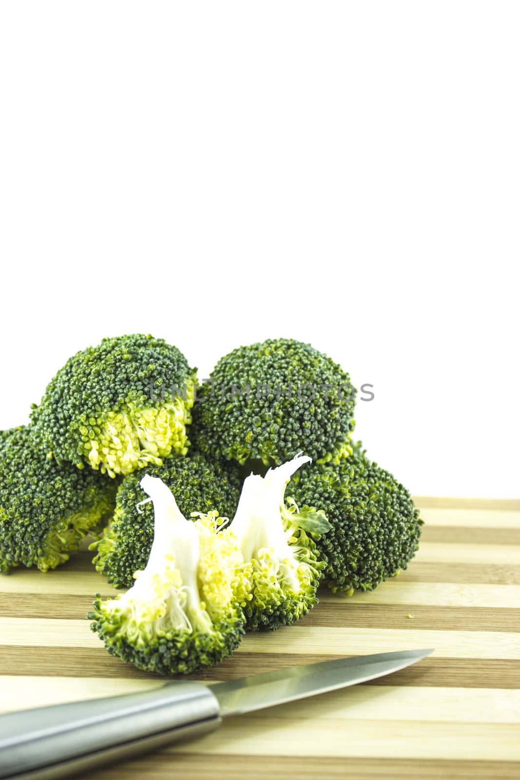 Fresh broccoli on wood with knife.