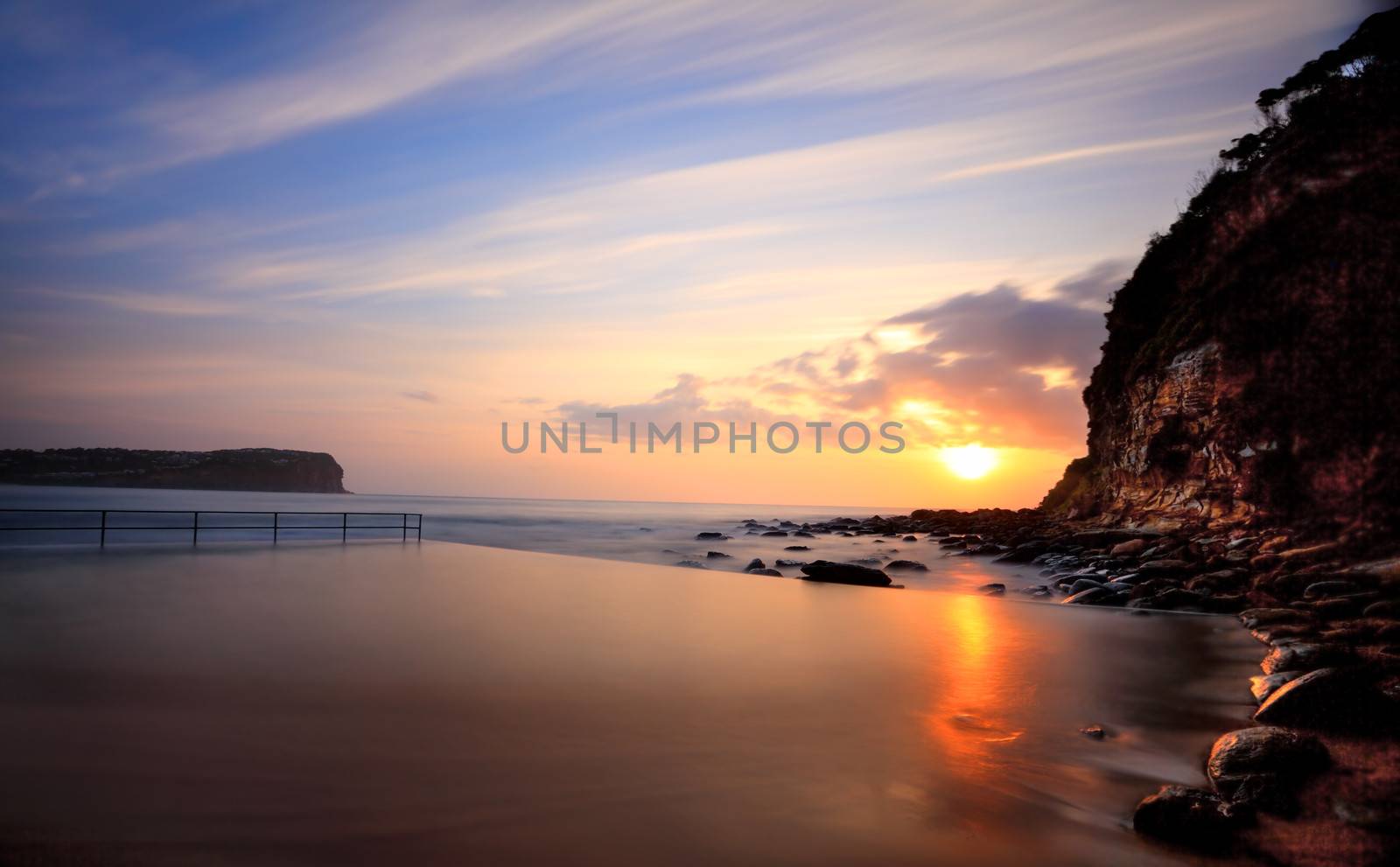 Sunrise at Macmasters Beach near the ocean pool high tide. Australia.   Long exposure.