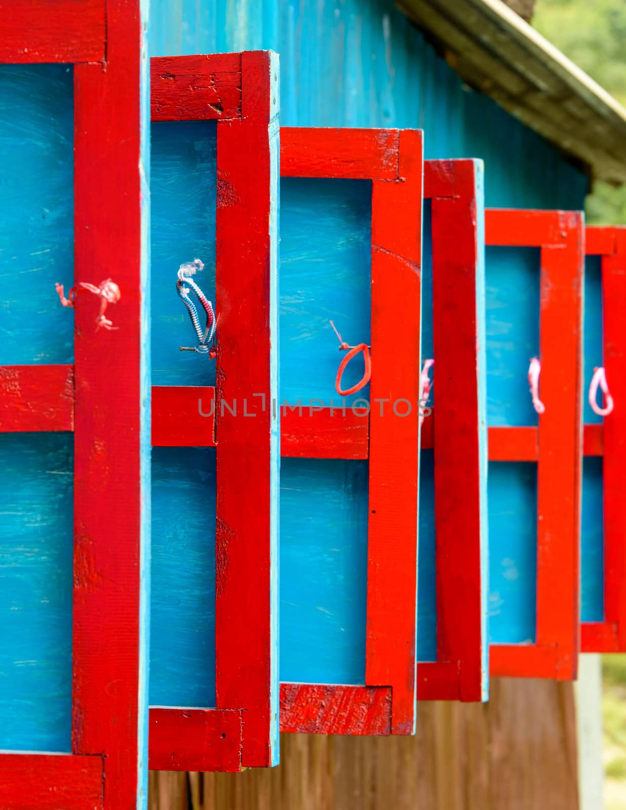 Red and blue wooden shutters by dutourdumonde
