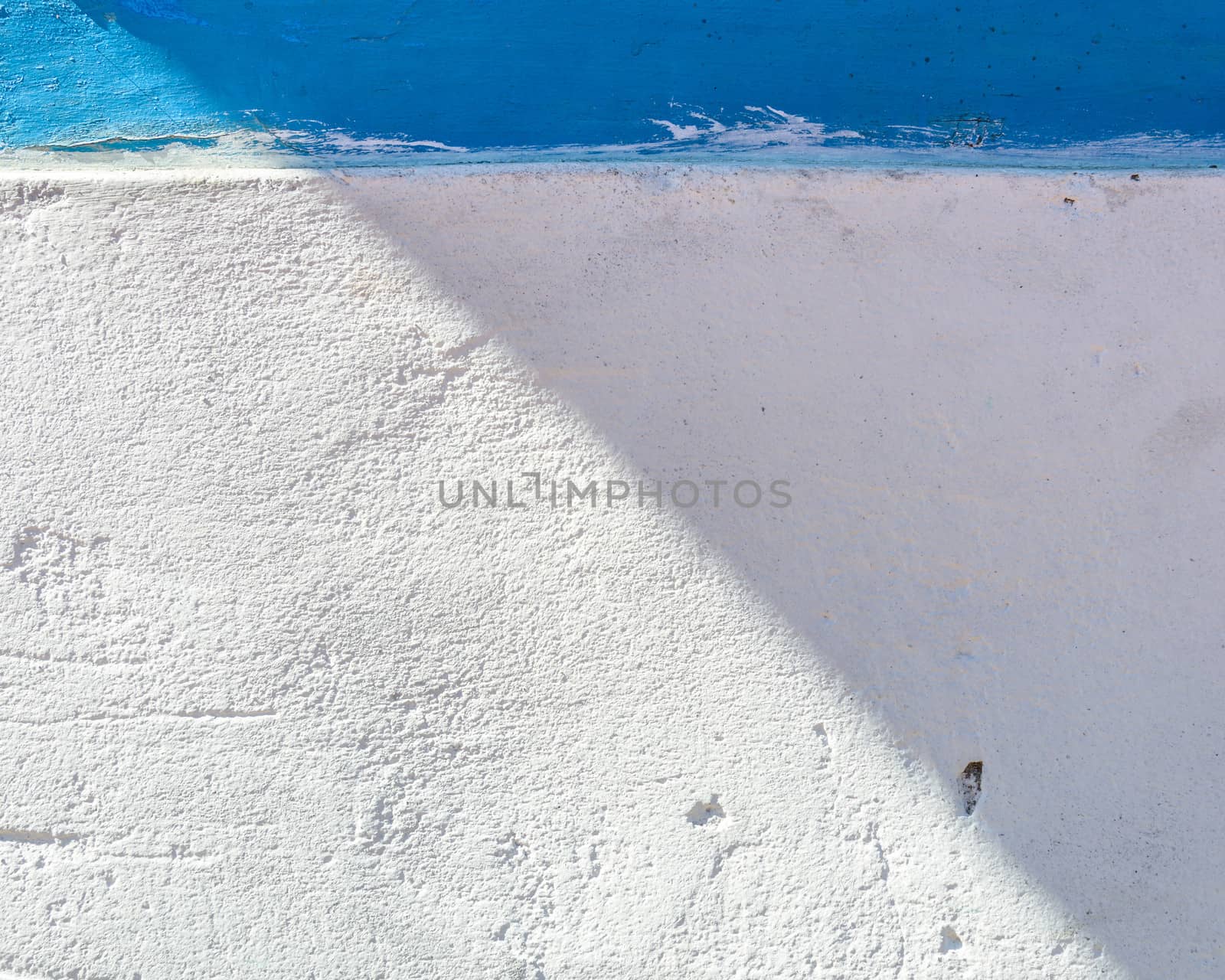 White and blue painted wall, part in the sun part in the shade