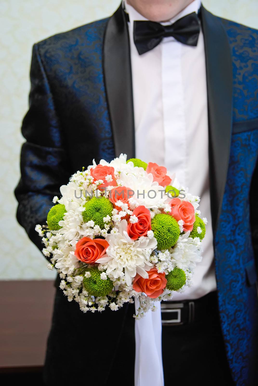 Bridal bouquet in the hand of the groom