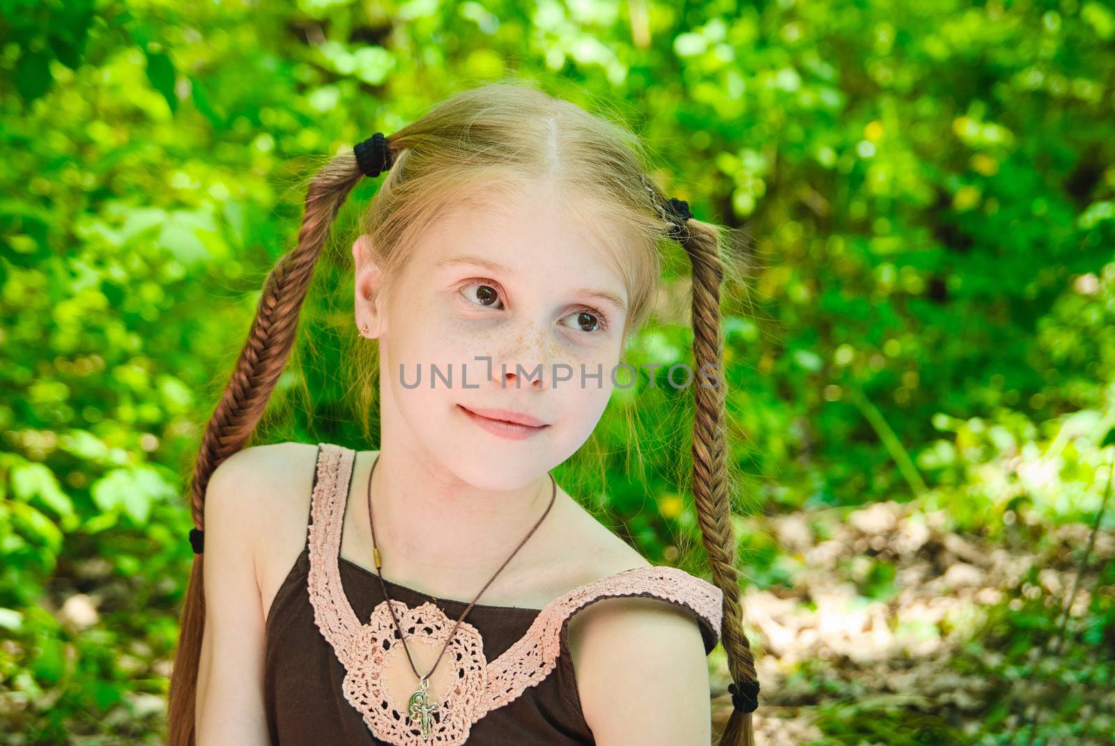 Portrait of happy little girl in the forest