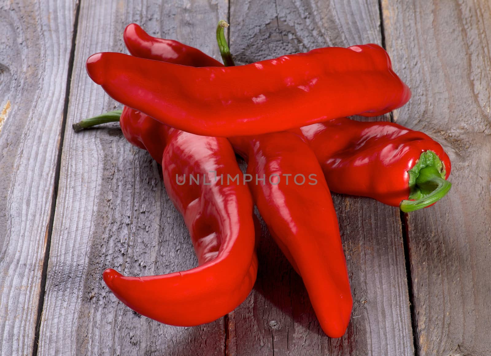 Perfect Raw Ripe Red Ramiro Peppers isolated on Rustic Wooden background