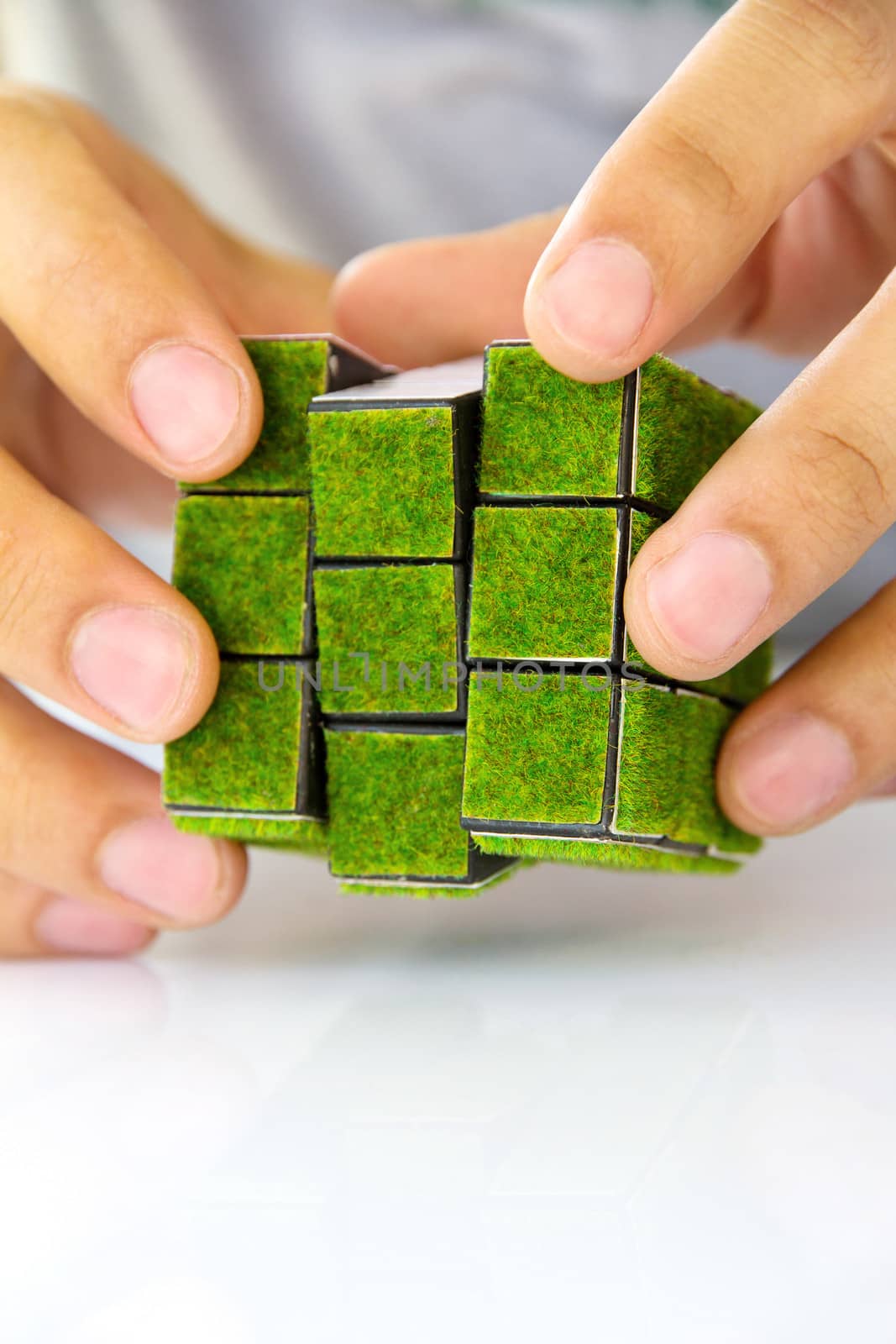 hand holding green rubik's cube concept by ponsulak