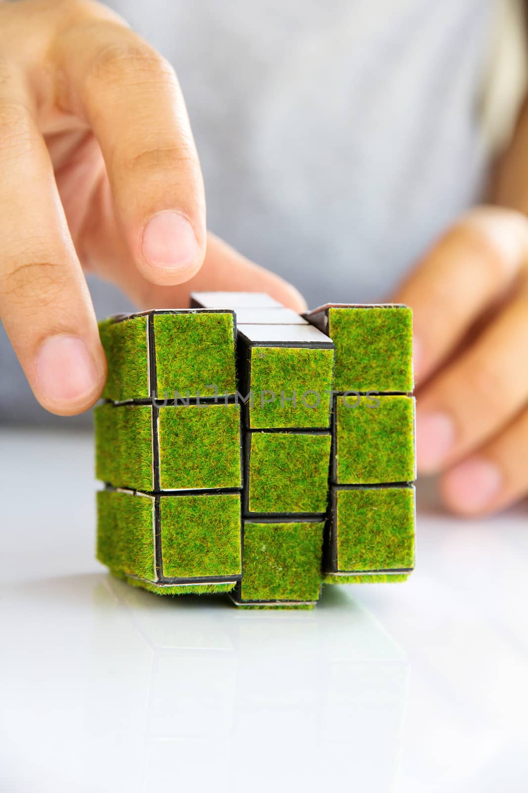 hand holding green rubik's cube concept by ponsulak