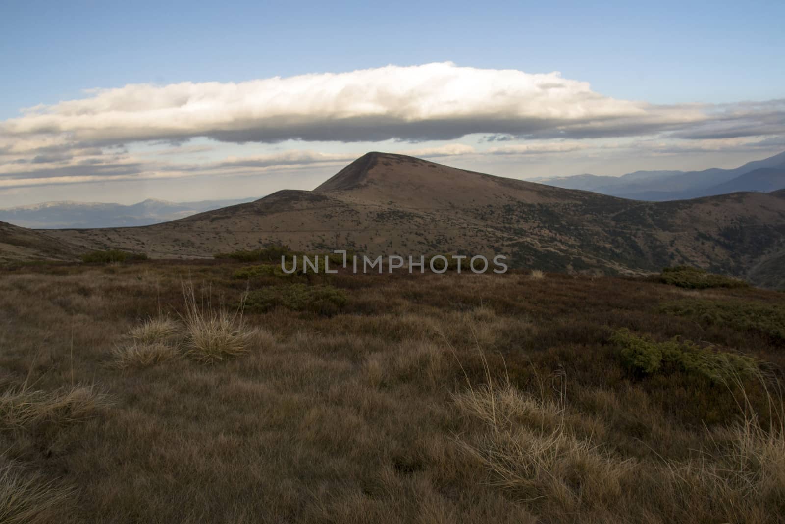 Mountain peaks in the autumn evening sky with clouds