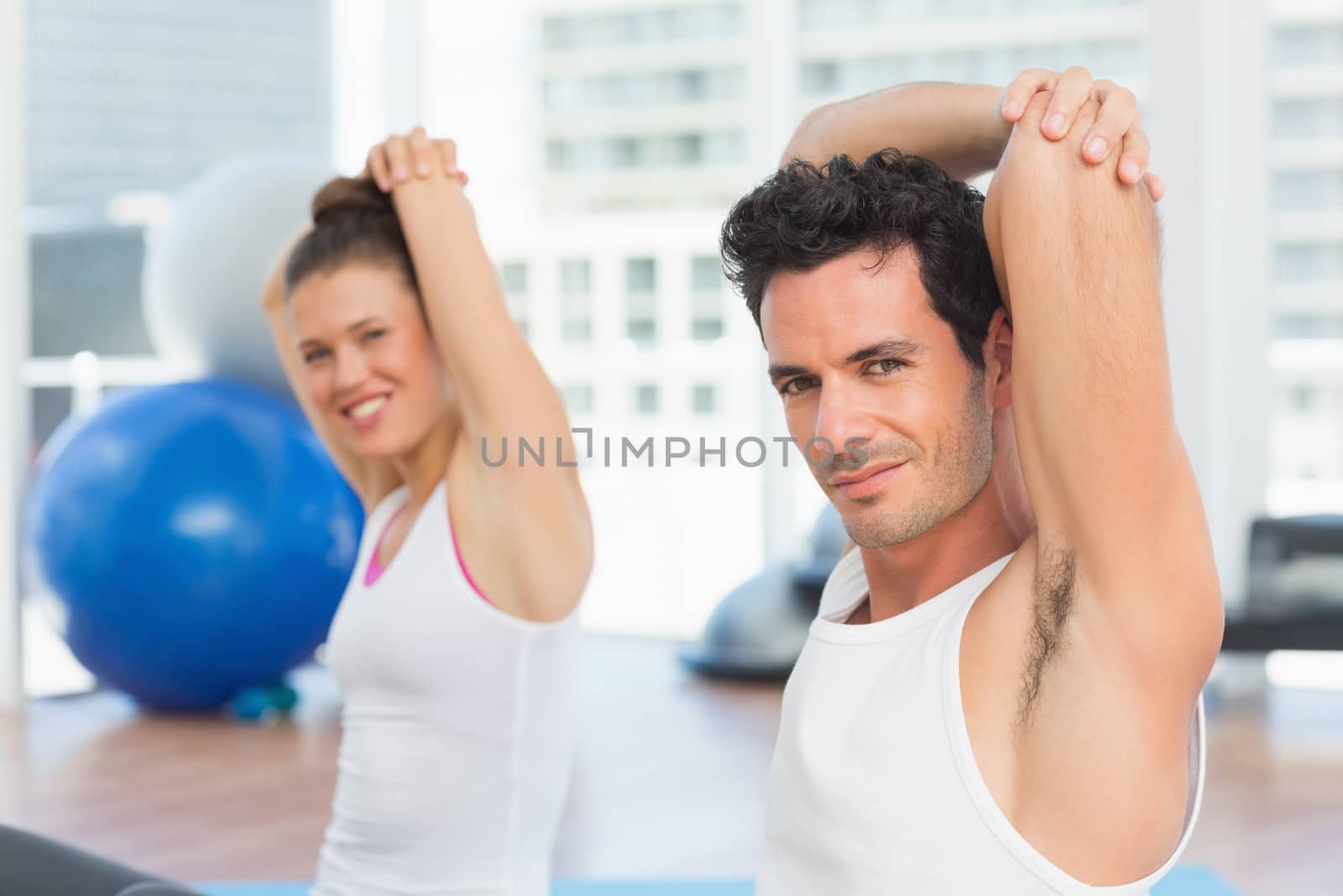 Sporty people stretching hands at yoga class by Wavebreakmedia