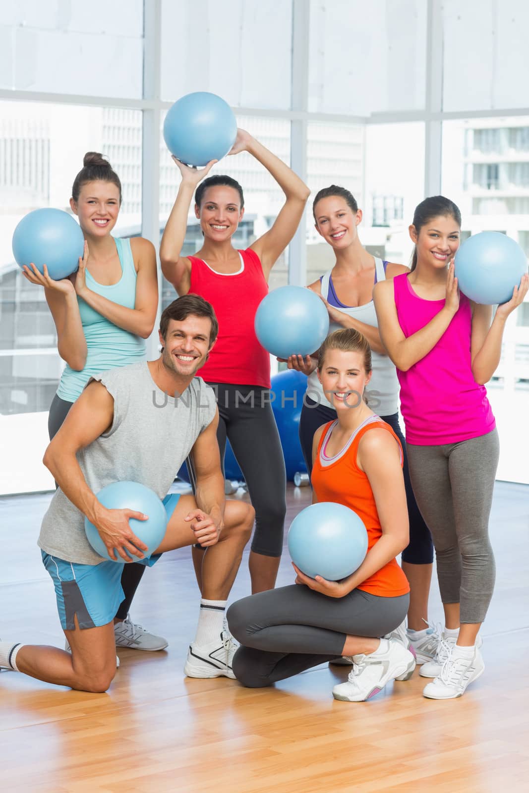 Fit young people with balls in exercise room by Wavebreakmedia