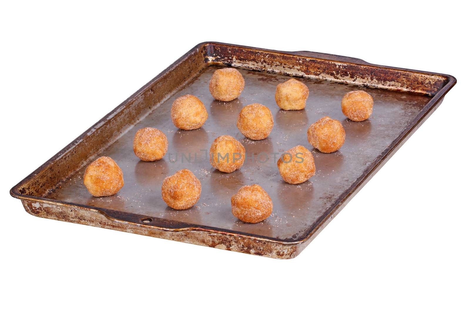 Balls of home-made dough for snickerdoodle cookies on a pan ready to be baked isolated against a white background