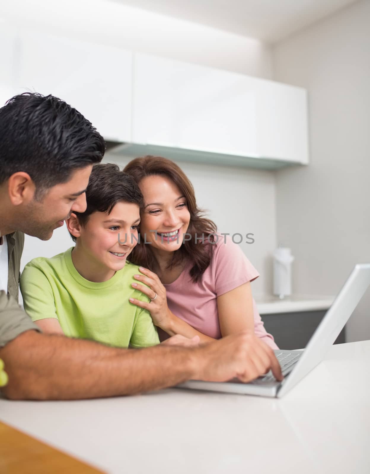 Smiling couple with son using laptop by Wavebreakmedia