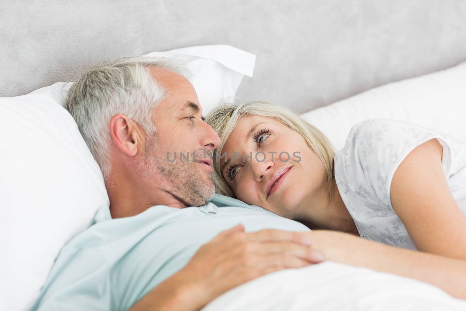 Loving mature couple lying in bed by Wavebreakmedia