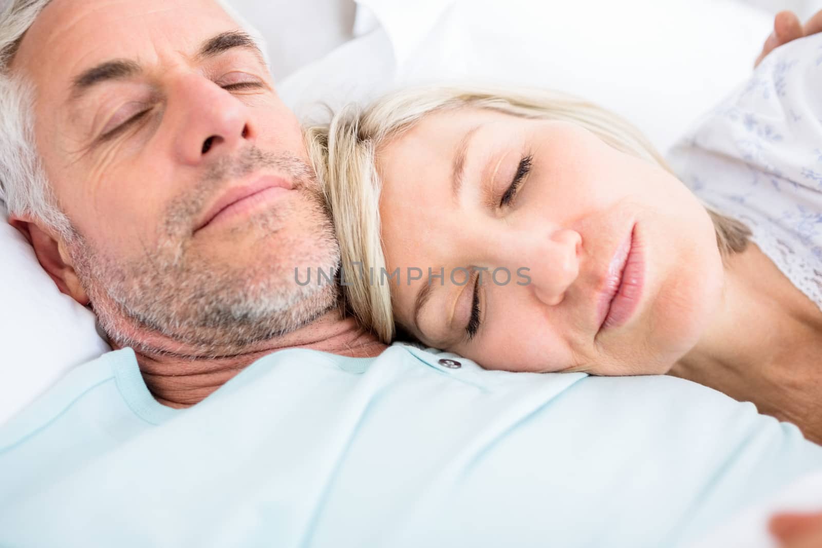 Closeup of a loving mature couple sleeping in bed at home