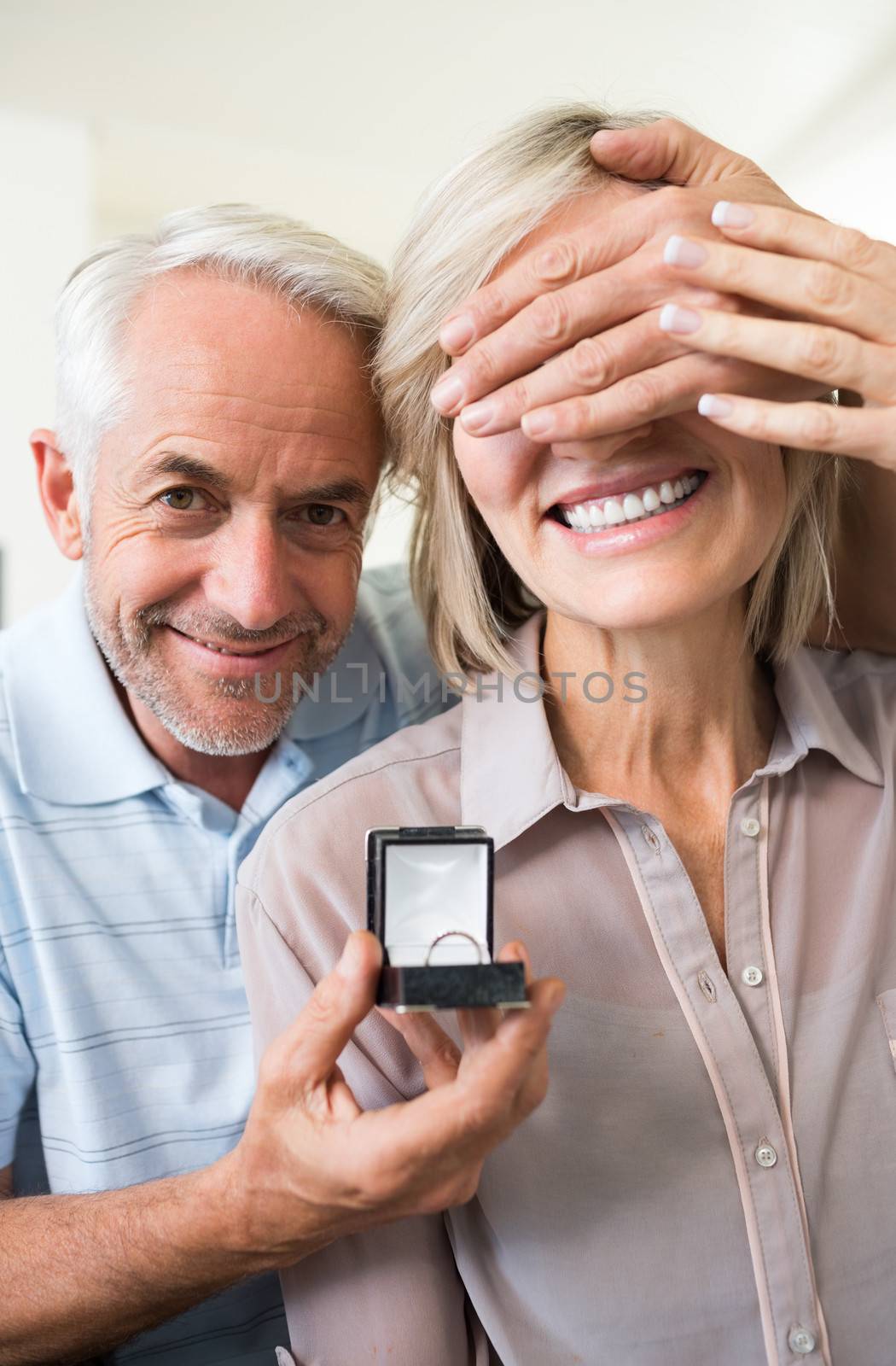 Closeup portrait of a smiling man surprising woman with a wedding ring