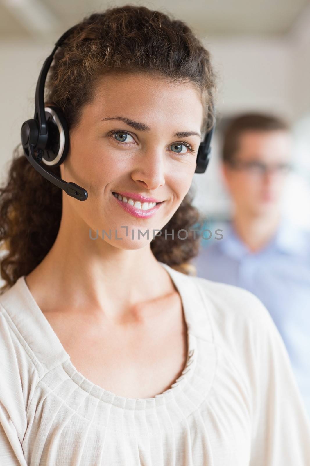 Closeup portrait of female customer service operator wearing headset in office