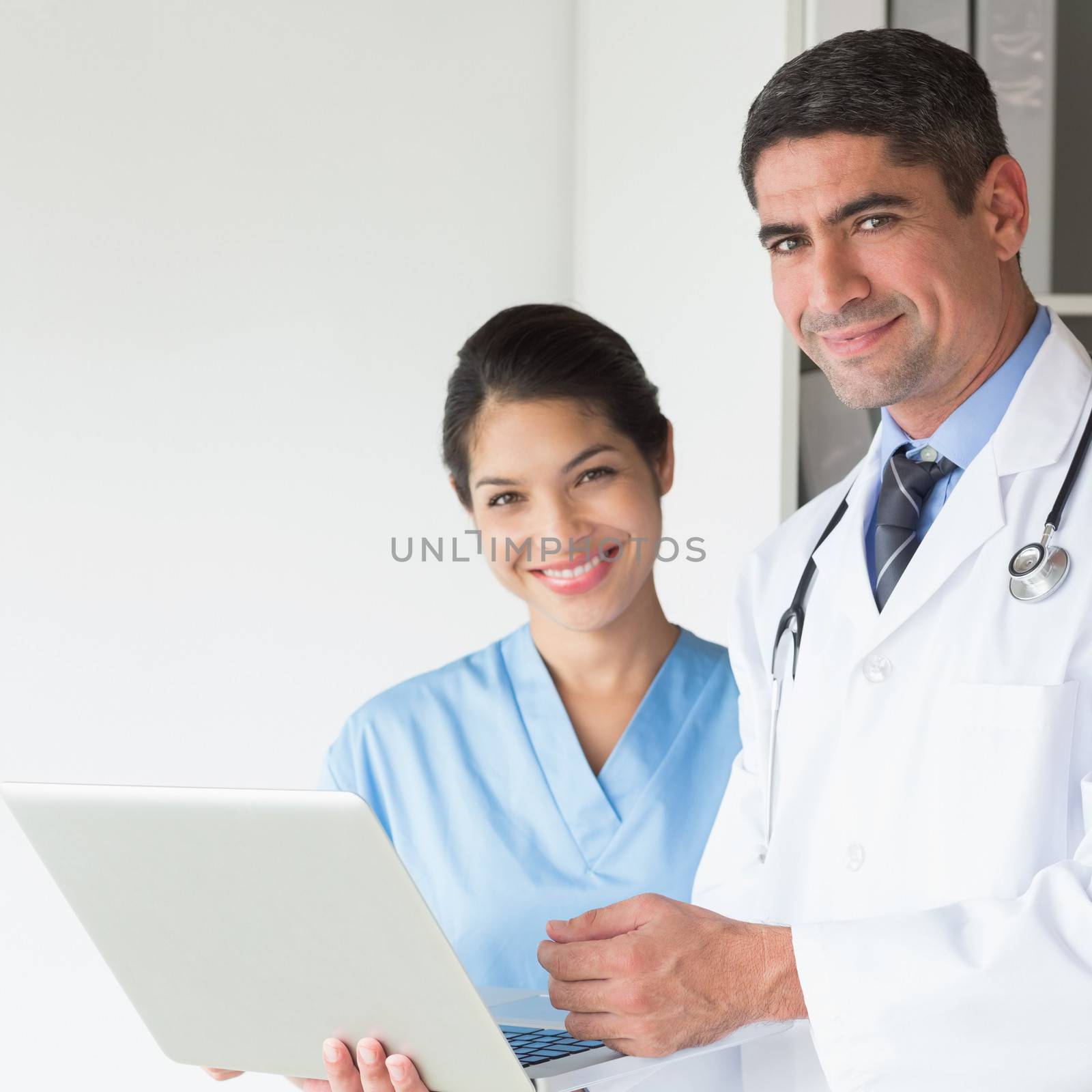 Confident doctor and nurse using laptop by Wavebreakmedia