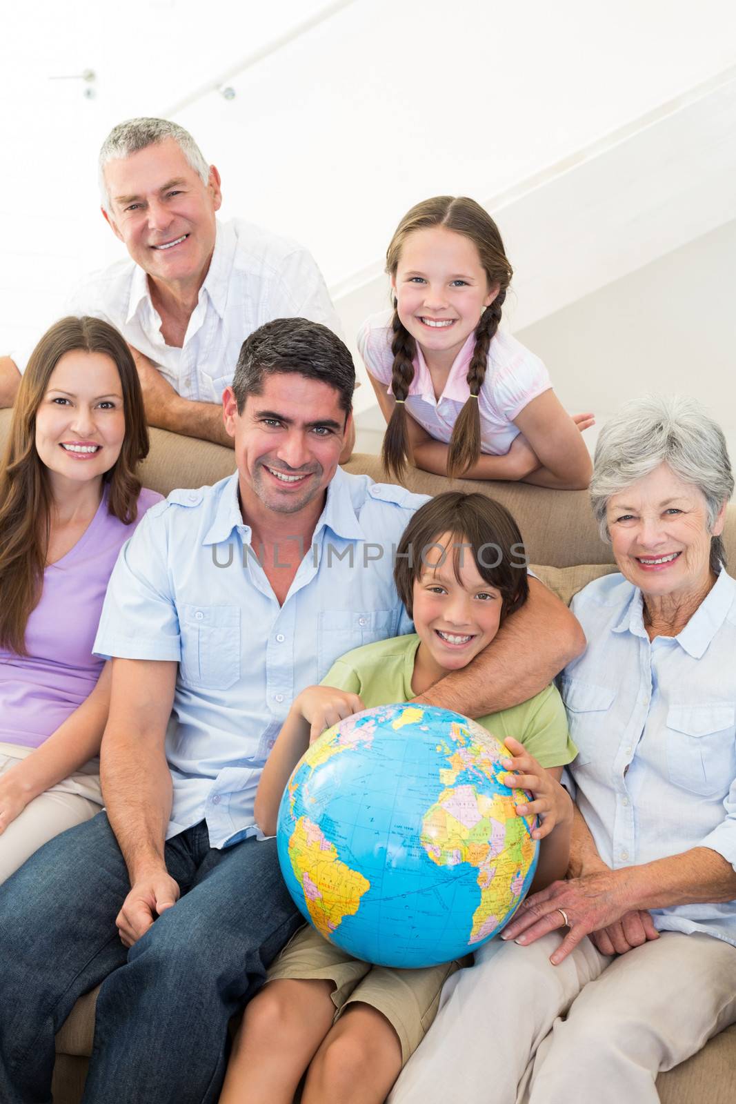Portrait of smiling multigeneration family with globe at home