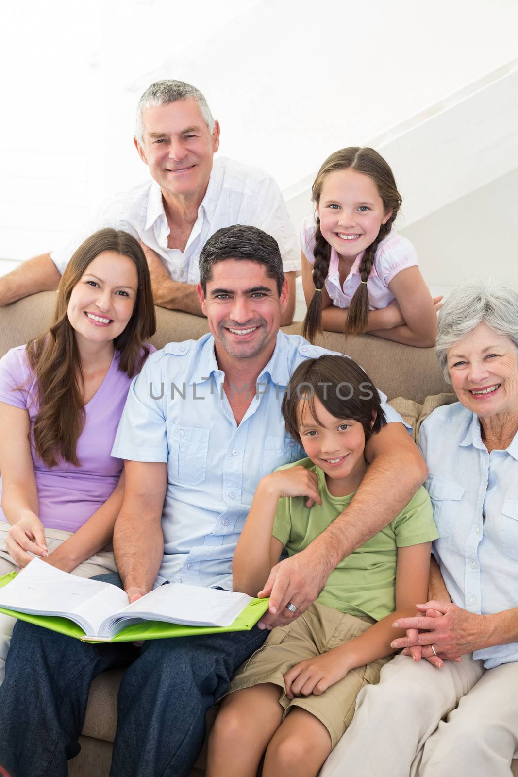 Portrait of happy multigeneration family with book at home