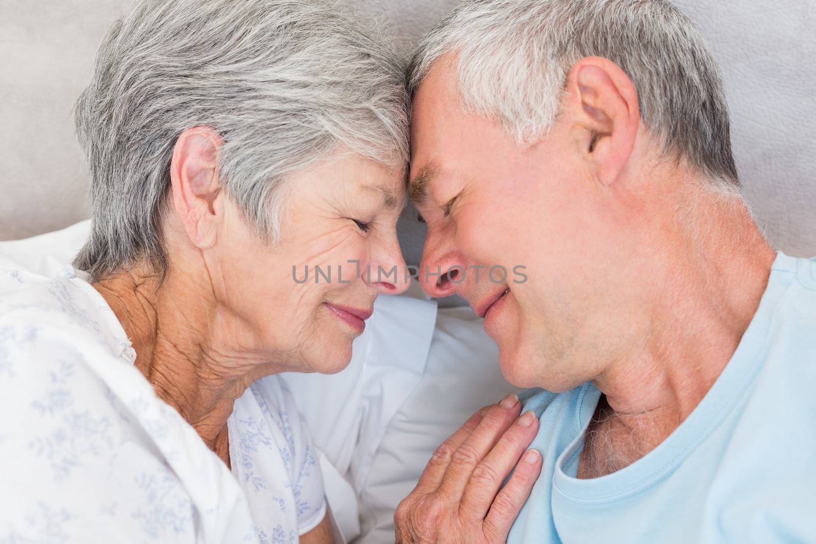 Romantic couple with head to head lying in bed