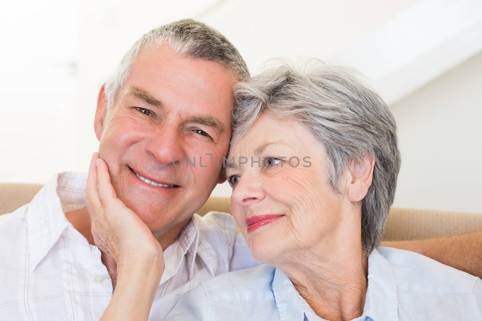 Loving senior woman touching husband at home