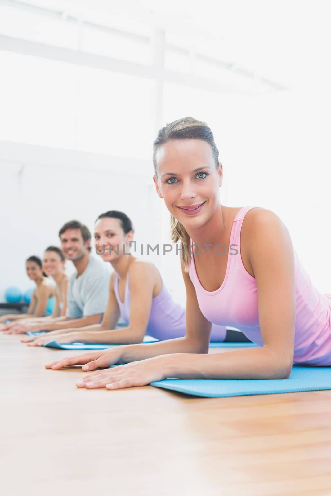 Side view portrait of fit class exercising in row at fitness studio