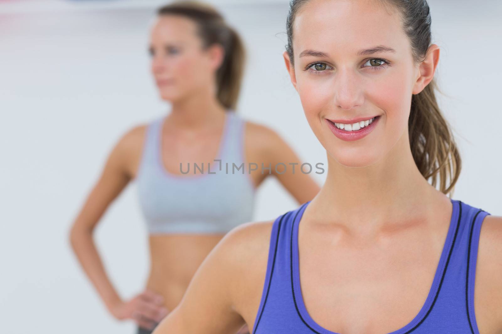 Portrait of fit young women in sports bra at fitness studio