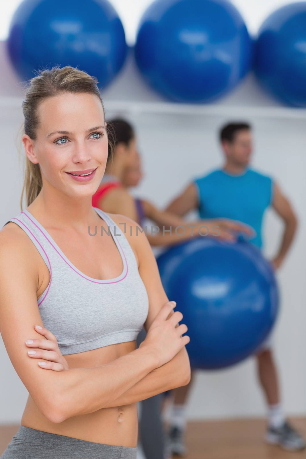 Young woman with friends in background at fitness studio by Wavebreakmedia