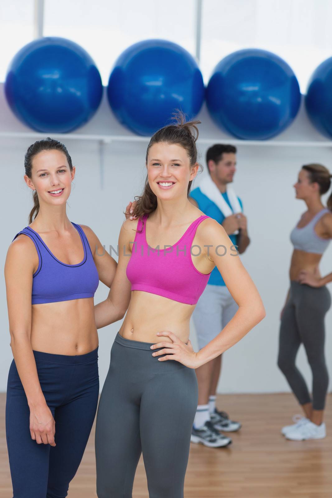 Fit women in sports bra with a couple in background by Wavebreakmedia