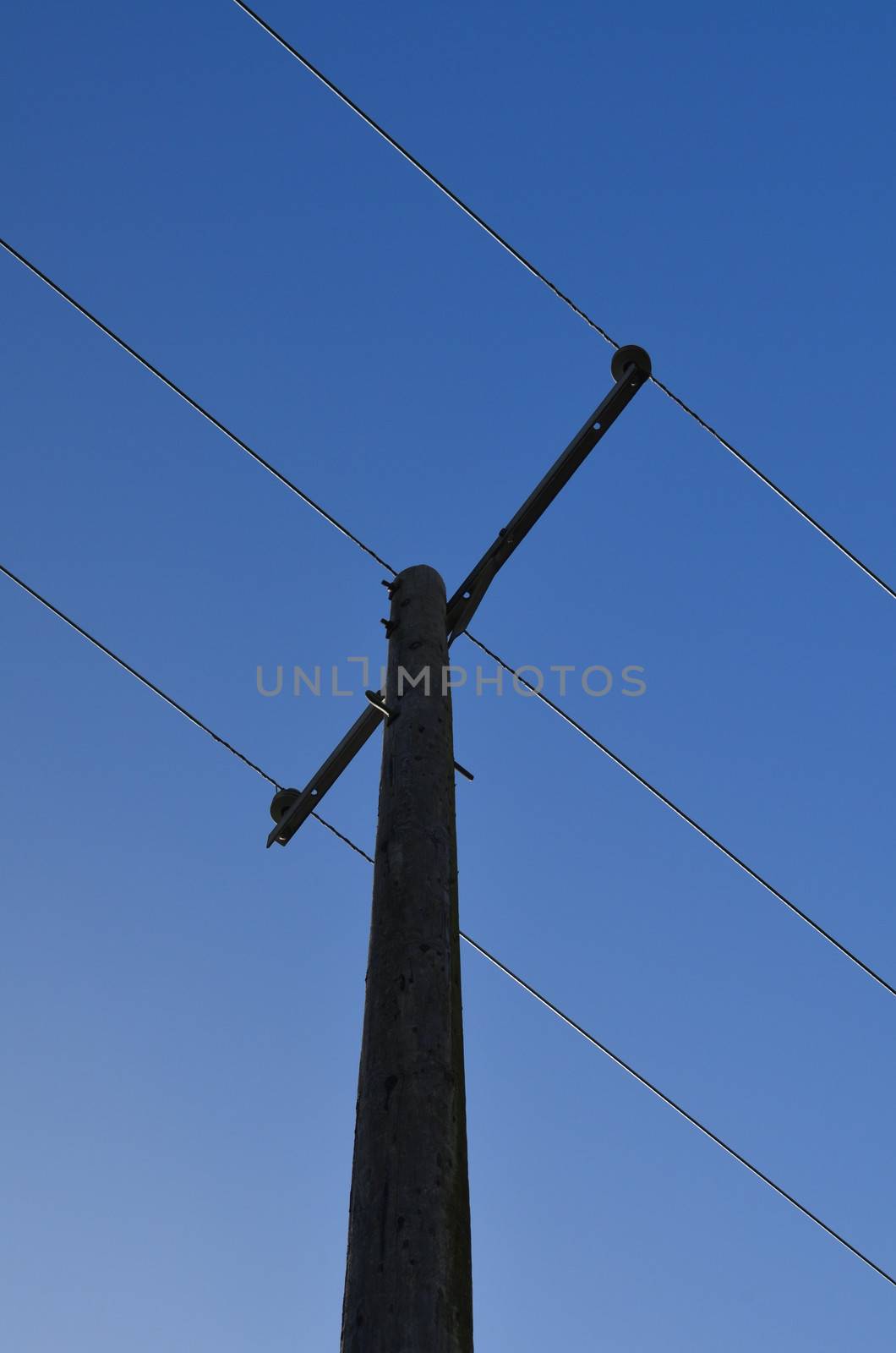 Wooden rural electricity pole with wires.