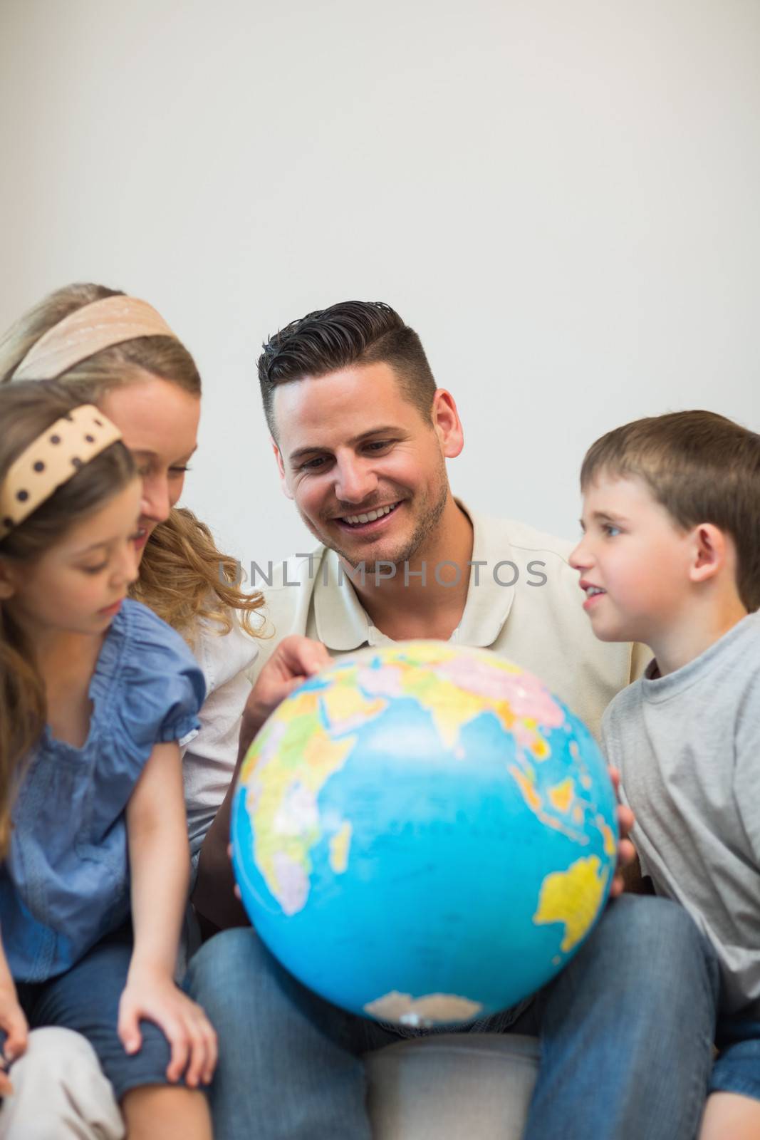Happy family eploring places on globe in house