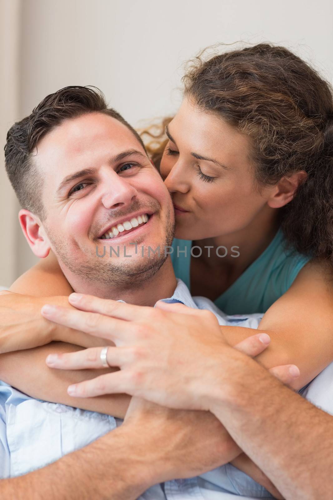 Romantic woman kissing man at home