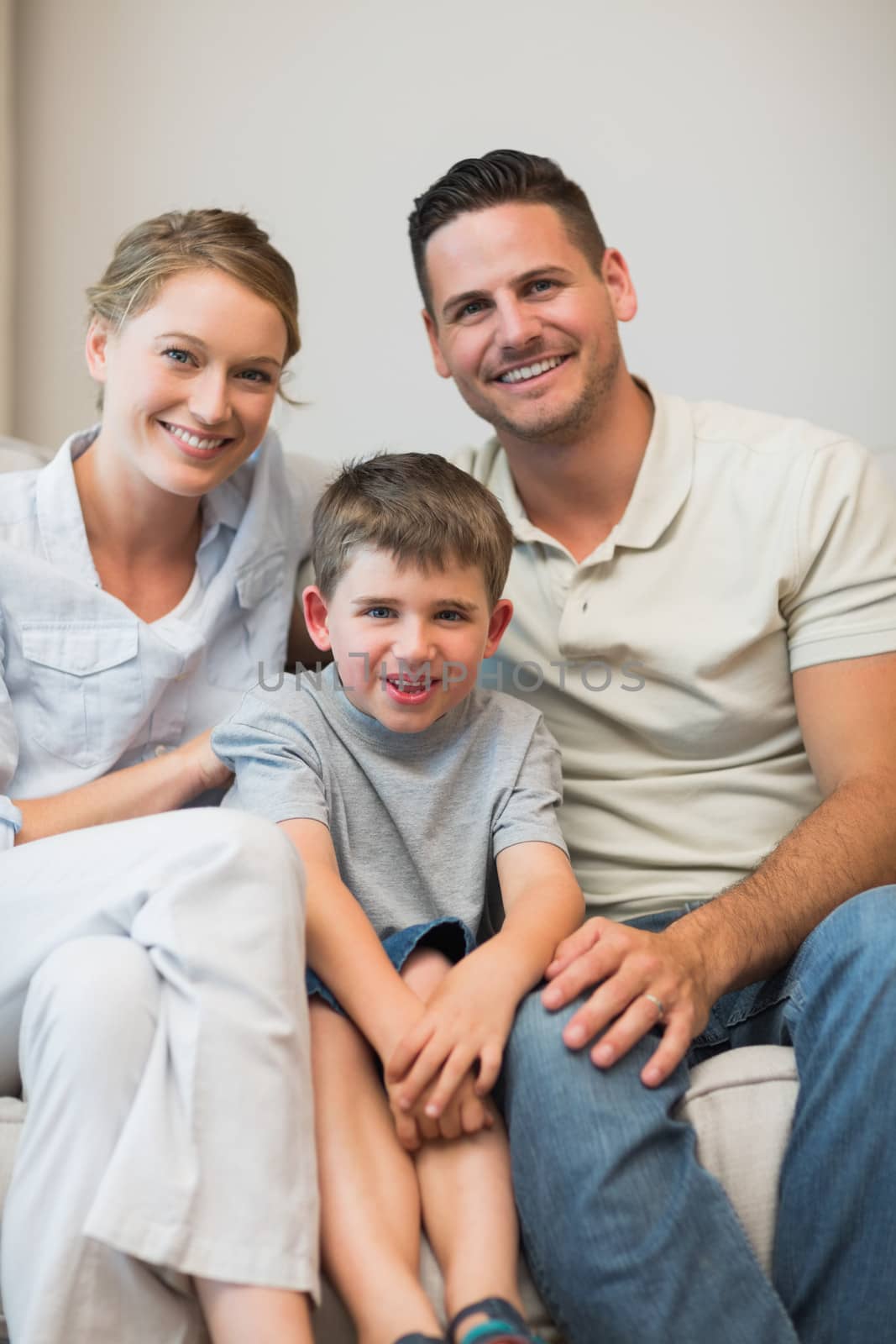 Portrait of happy family sitting together on sofa in living room
