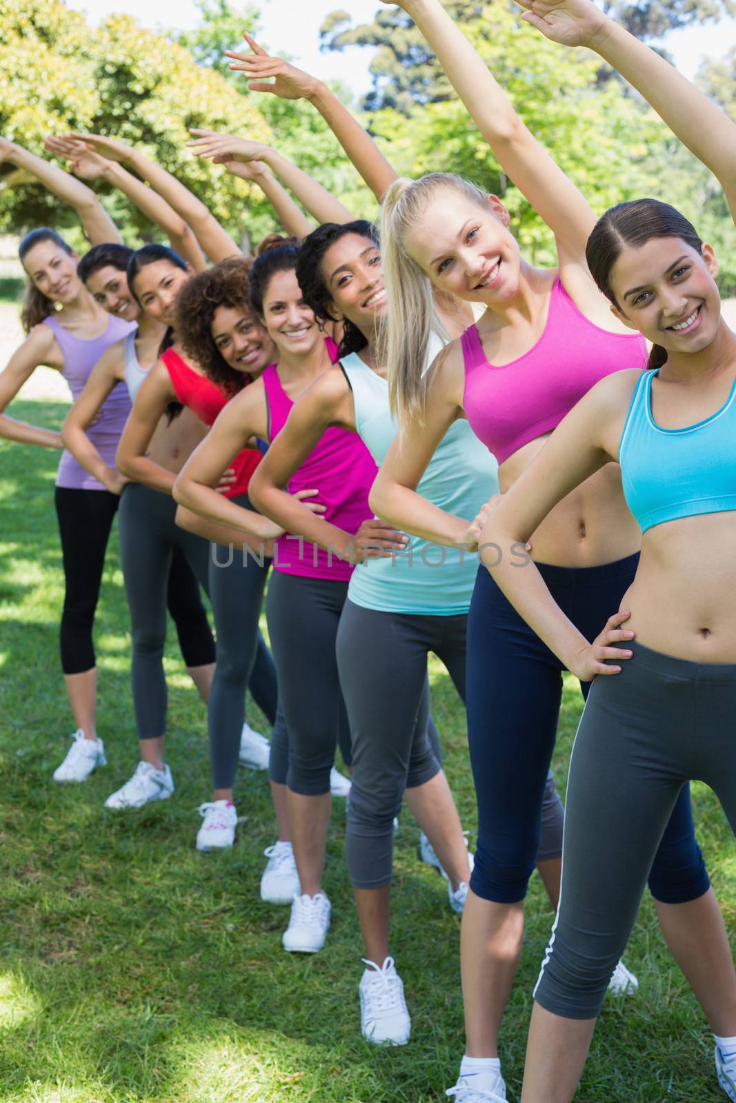 Women performing stretching exercise at park by Wavebreakmedia