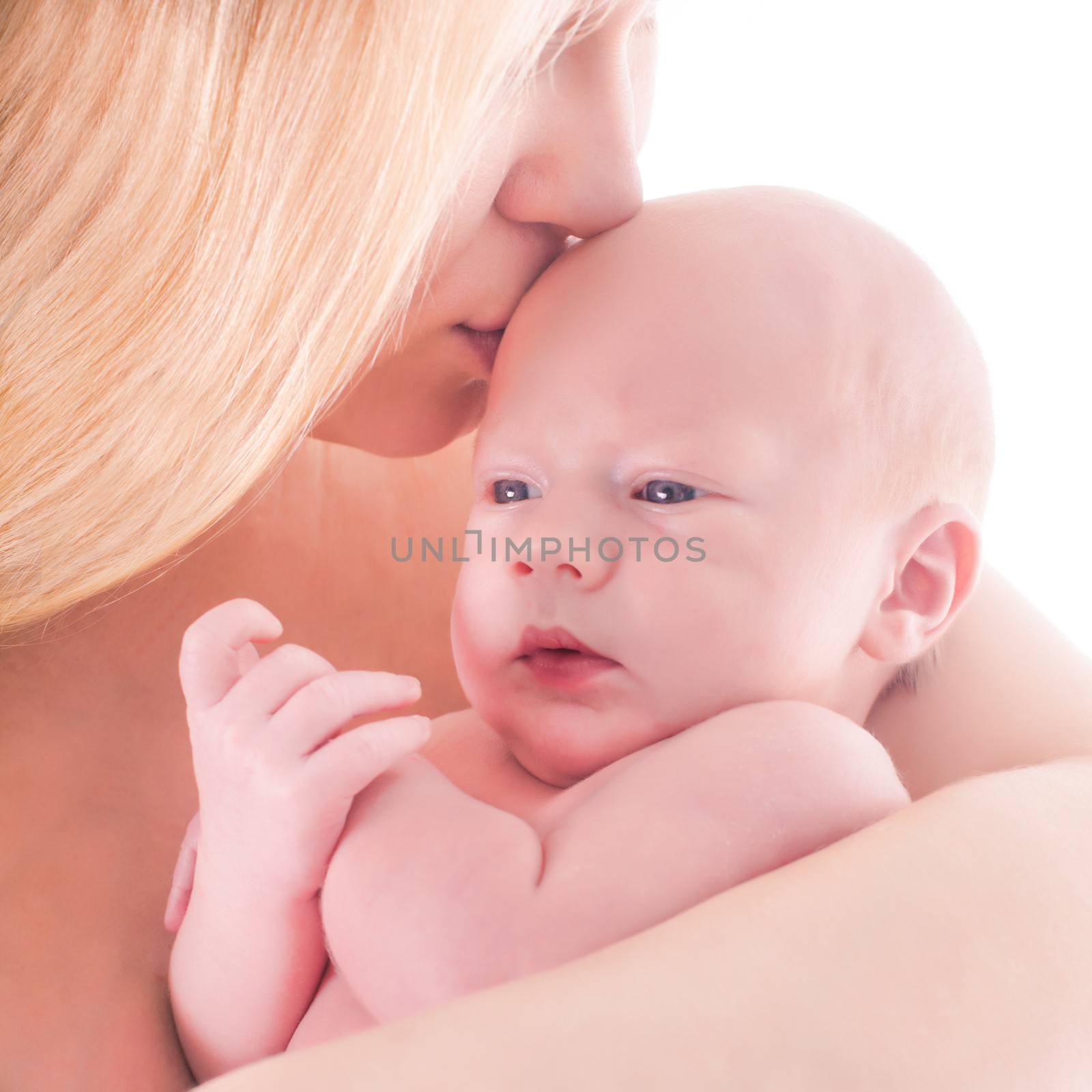 Mother kisses her baby, close up portrait
