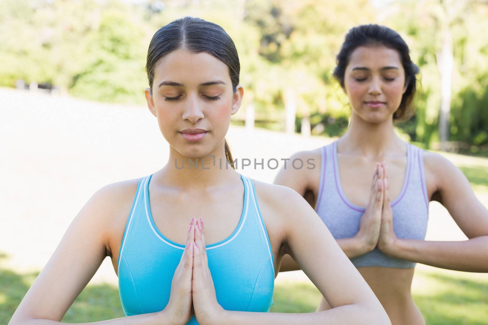Women meditating in park by Wavebreakmedia