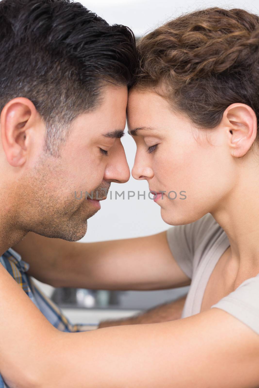 Romantic couple hugging at home in kitchen