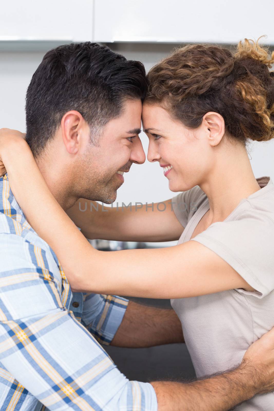 Romantic smiling couple hugging at home in kitchen