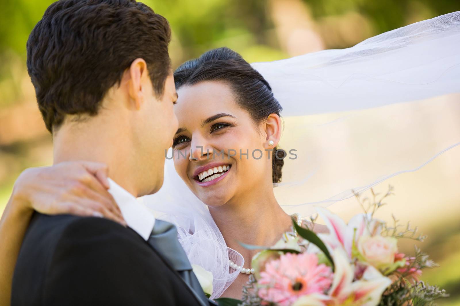 Close-up of a romantic newlywed couple looking at each other in the park