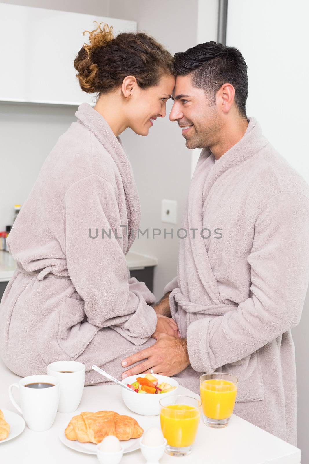 Romantic couple in bathrobes having breakfast together by Wavebreakmedia