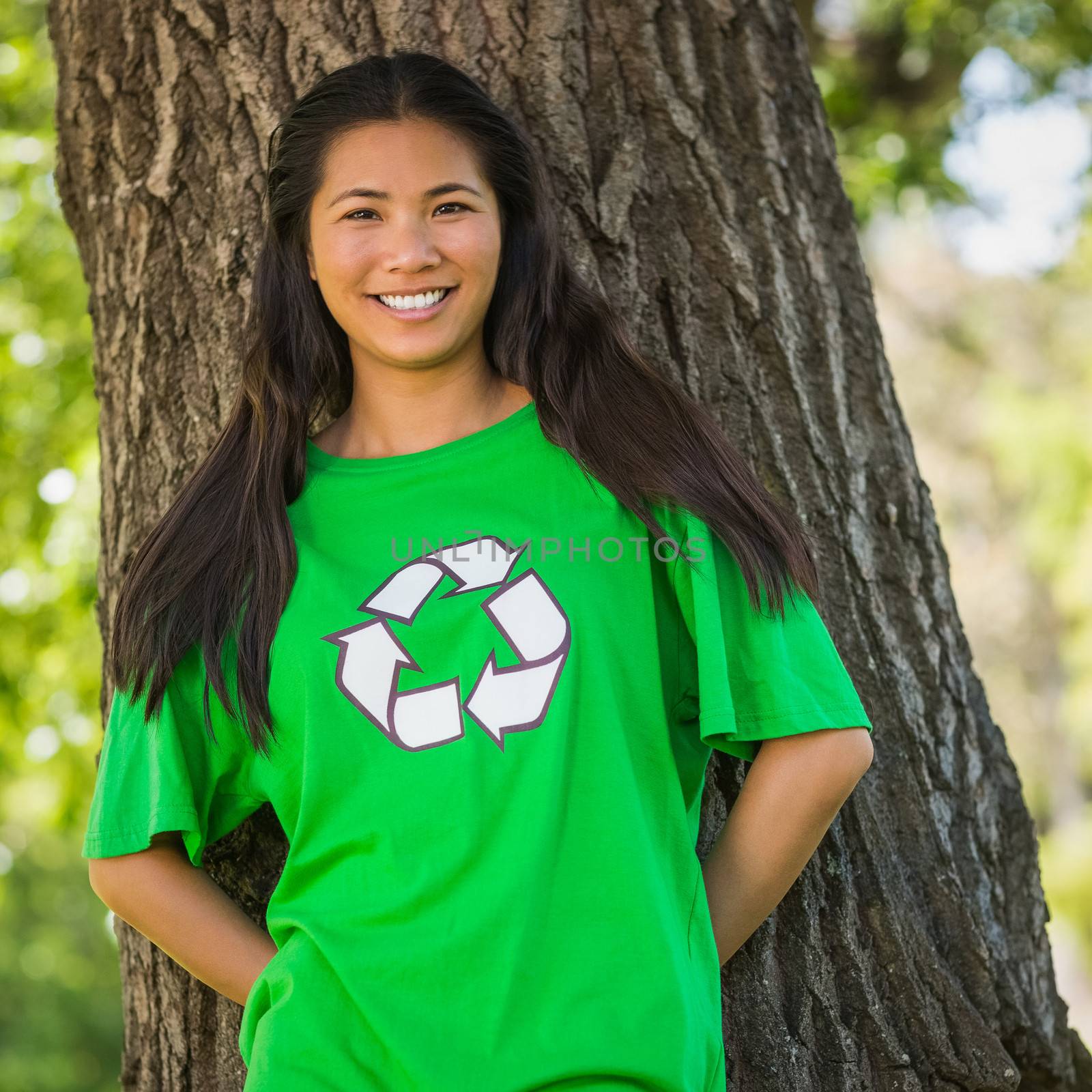 Smiling woman wearing green recycling t-shirt in park by Wavebreakmedia