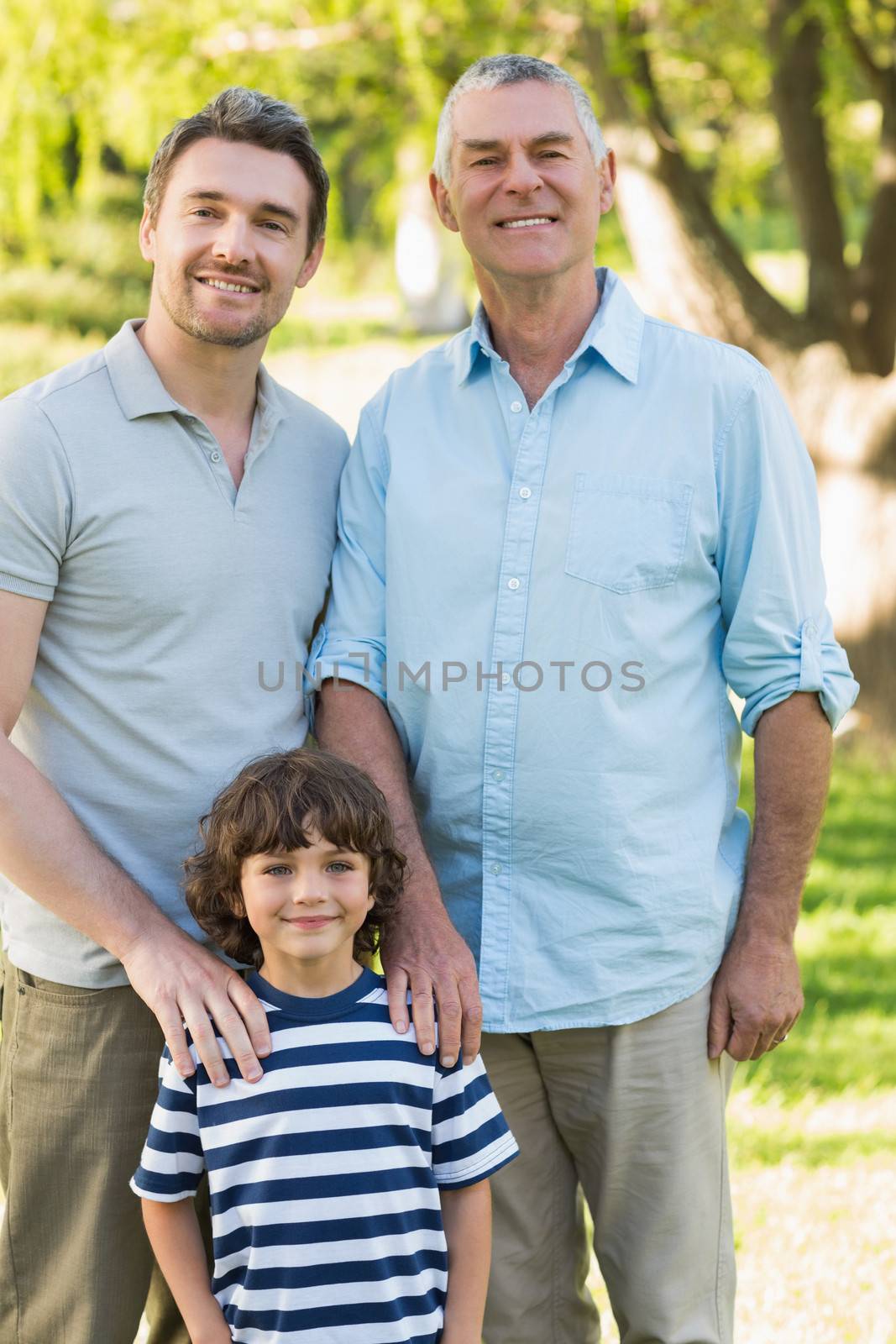 Grandfather father and son smiling at park by Wavebreakmedia
