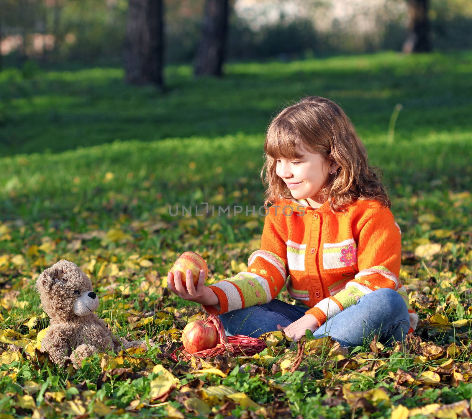 beautiful little girl and teddy bear in park