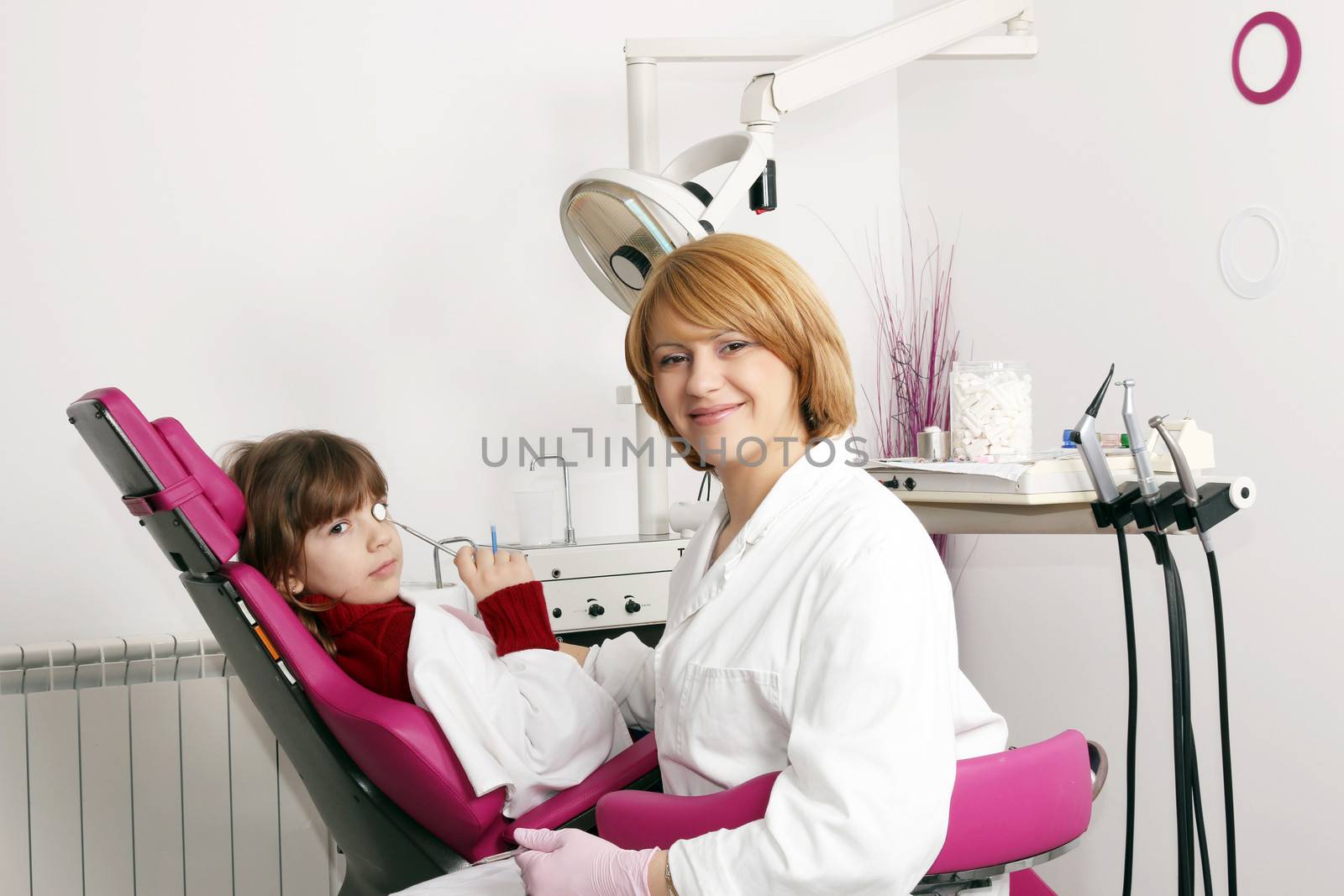 little girl and female dentist in dental practice by goce