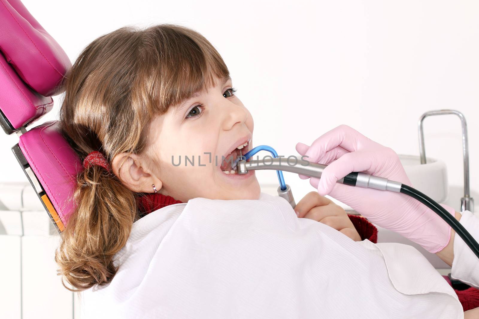 little girl with open mouth during drilling treatment at the den by goce
