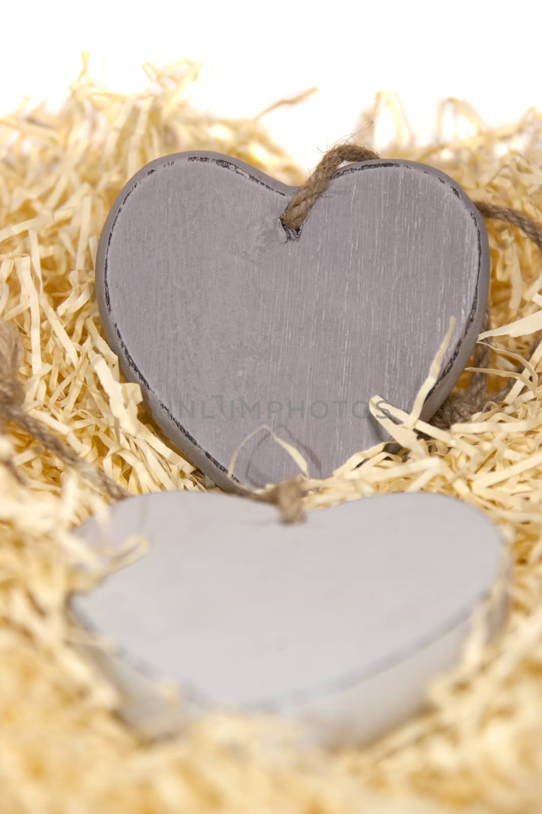 two wooden hearts in a love nest made of straw