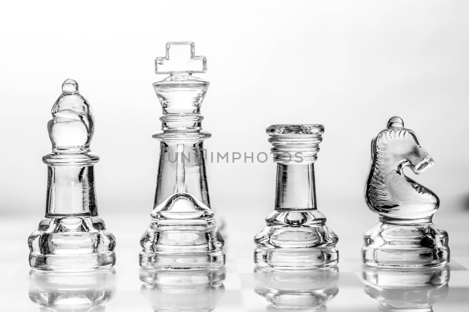 bishop, king, rook and knight chess pieces made out of glass