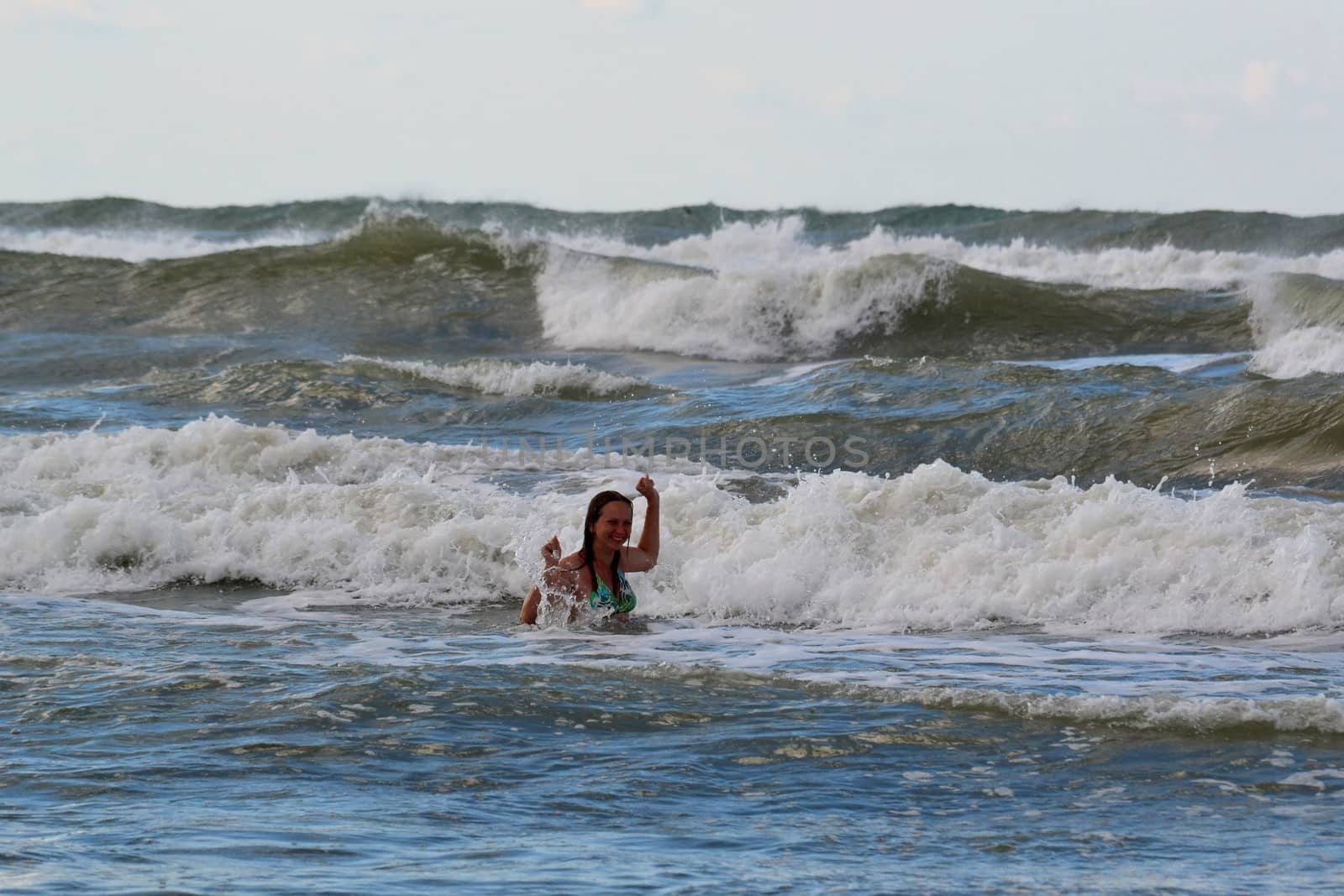 The woman in the sea against big waves