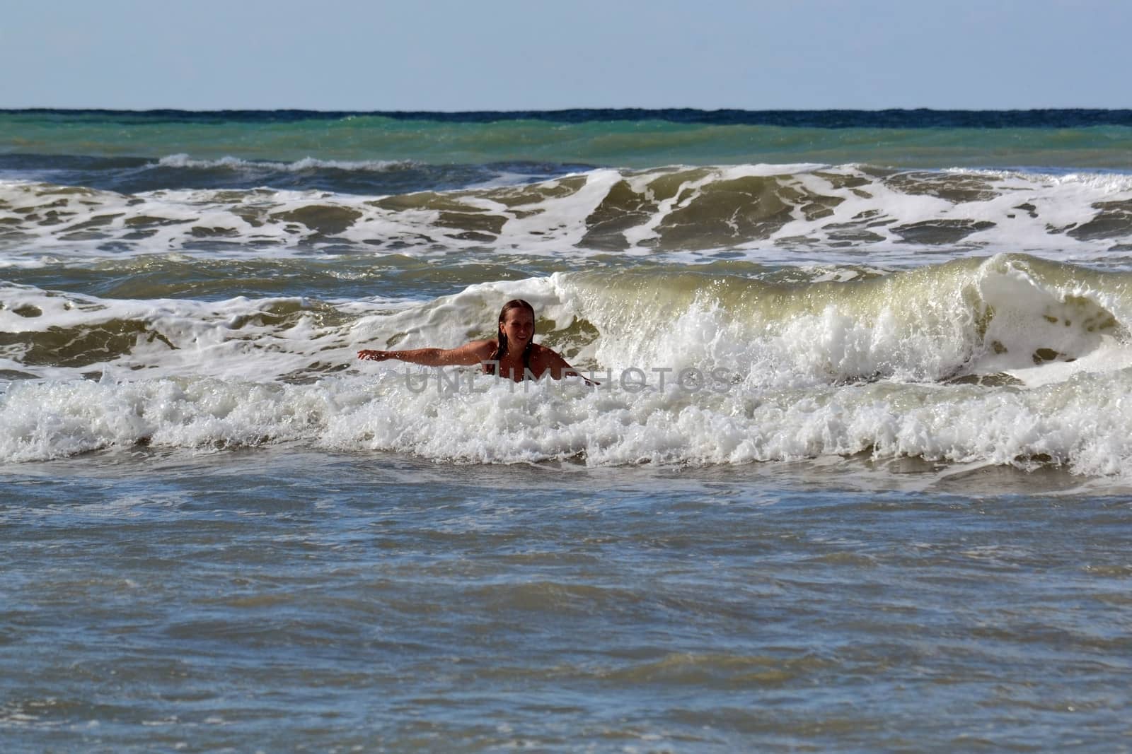 The woman in the sea against big waves