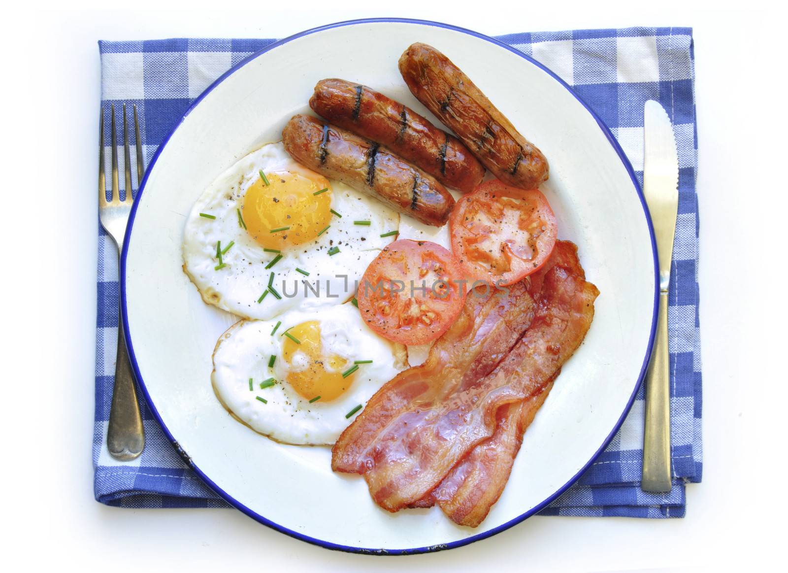 Fried eggs, sausages and bacon on a plate over a white background