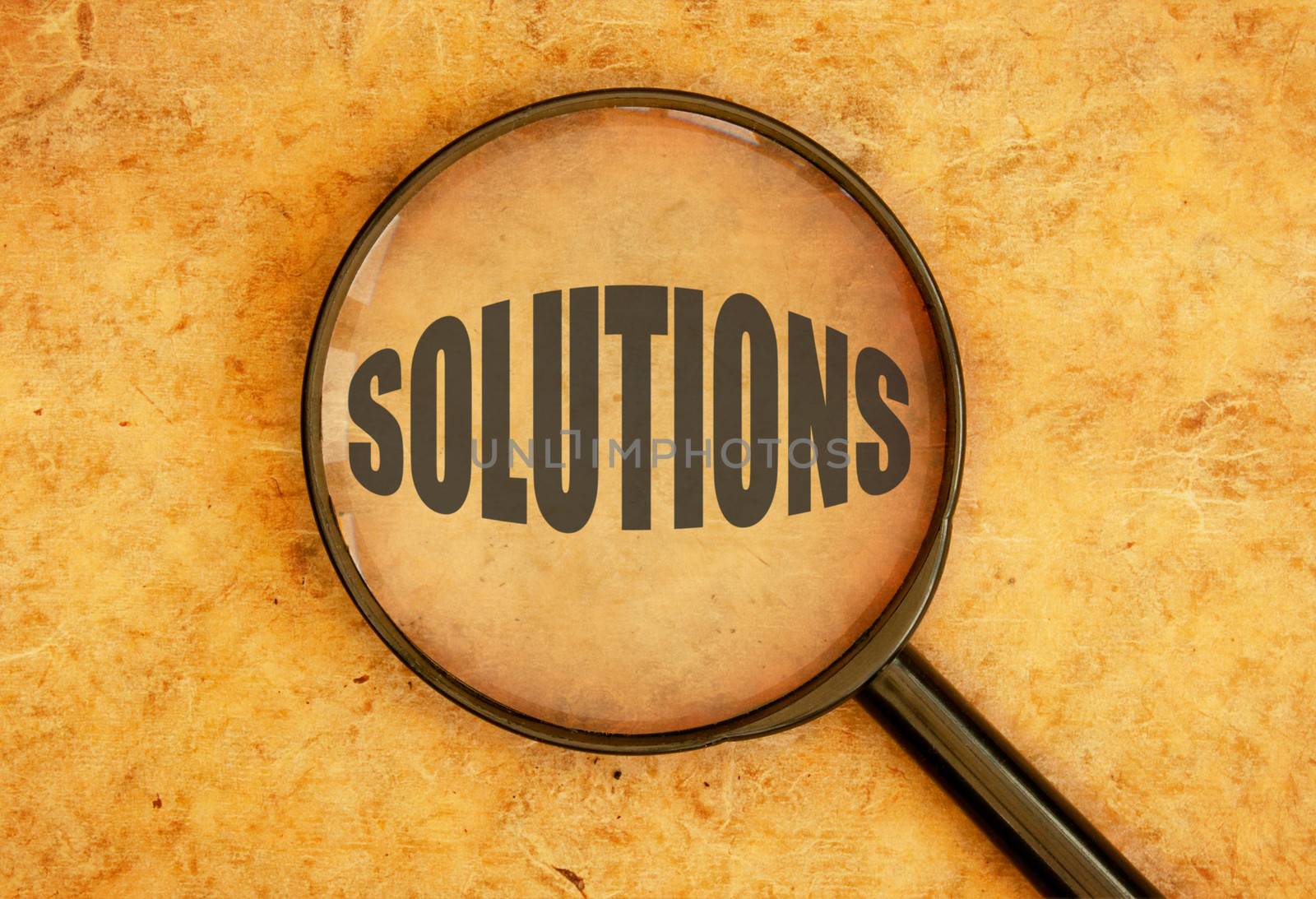 Magnifying glass focusing on the word solutions 