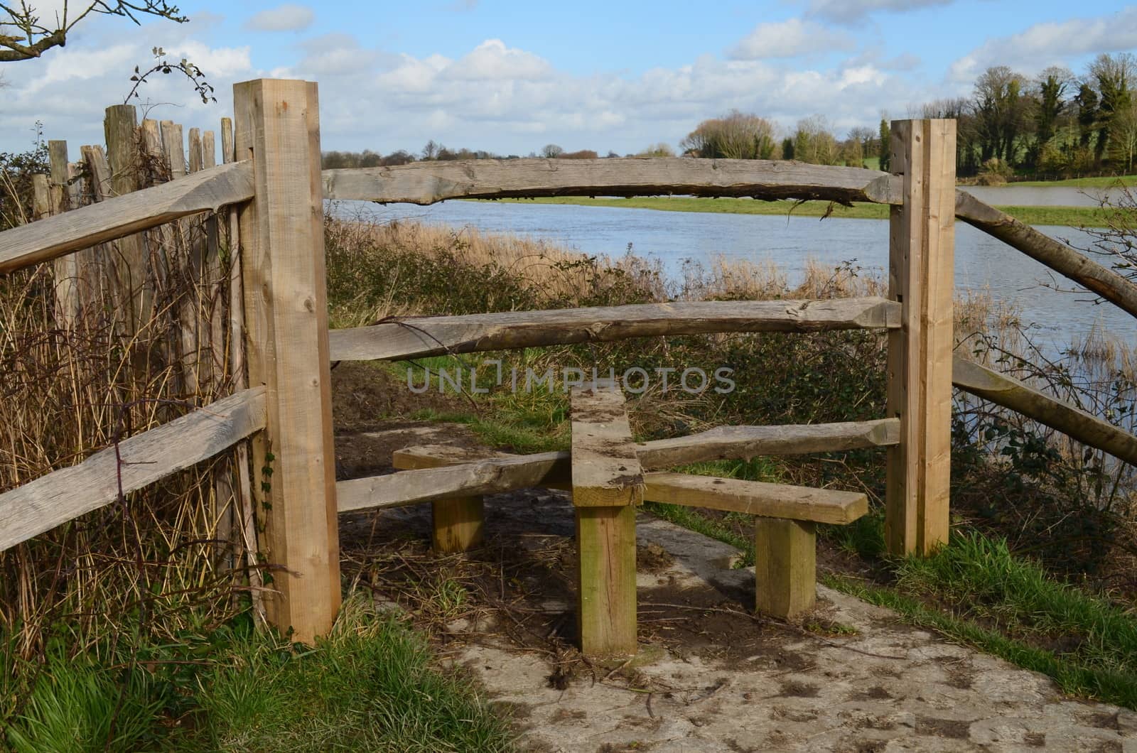 Wooden stile gate next to a river.